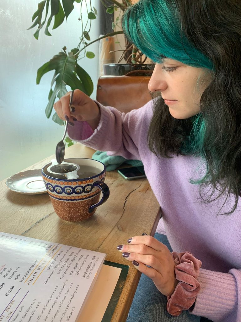 Izabela Jordanoska sitting at a table with a cup of tea.